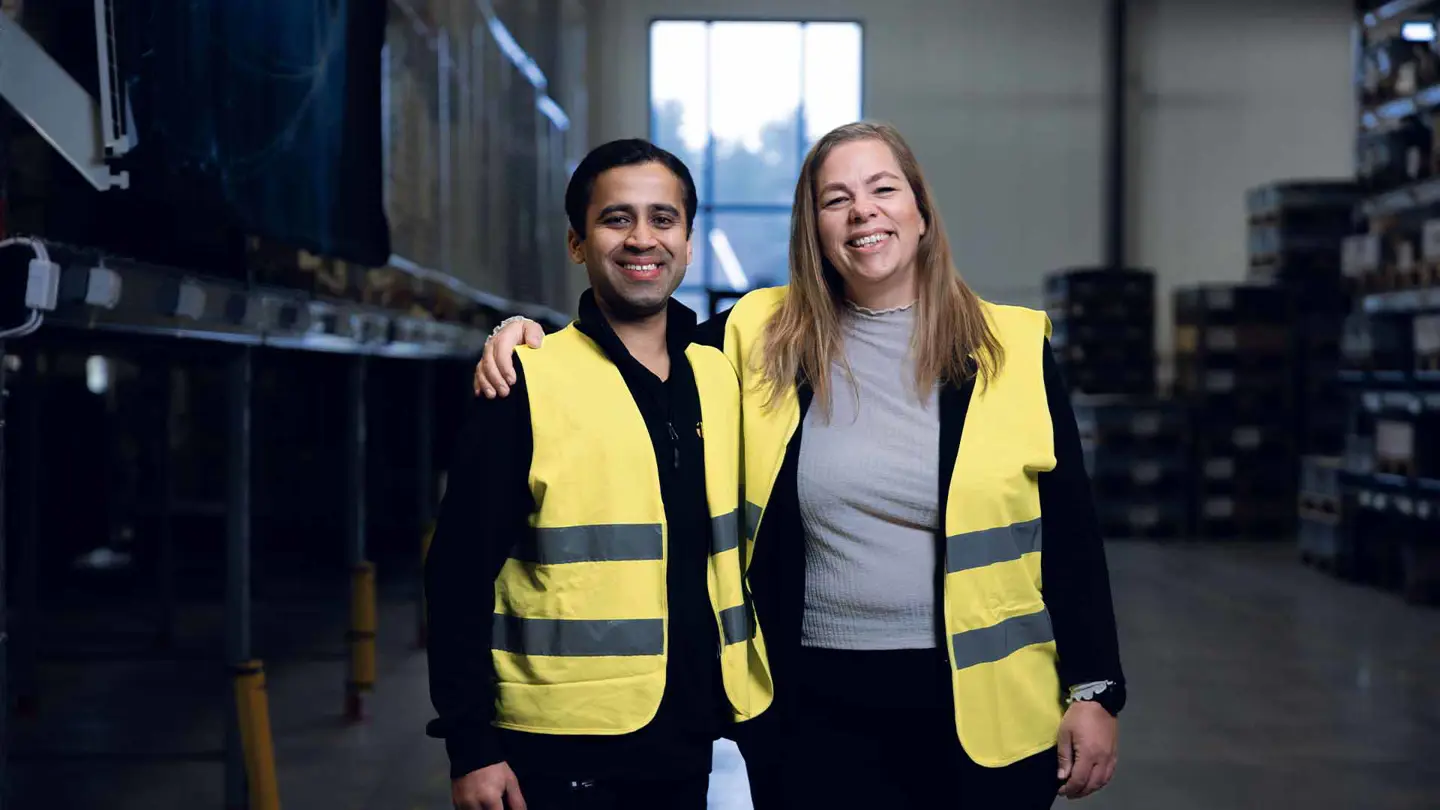 A man and a woman holding their arms around eachother in a warehouse environment