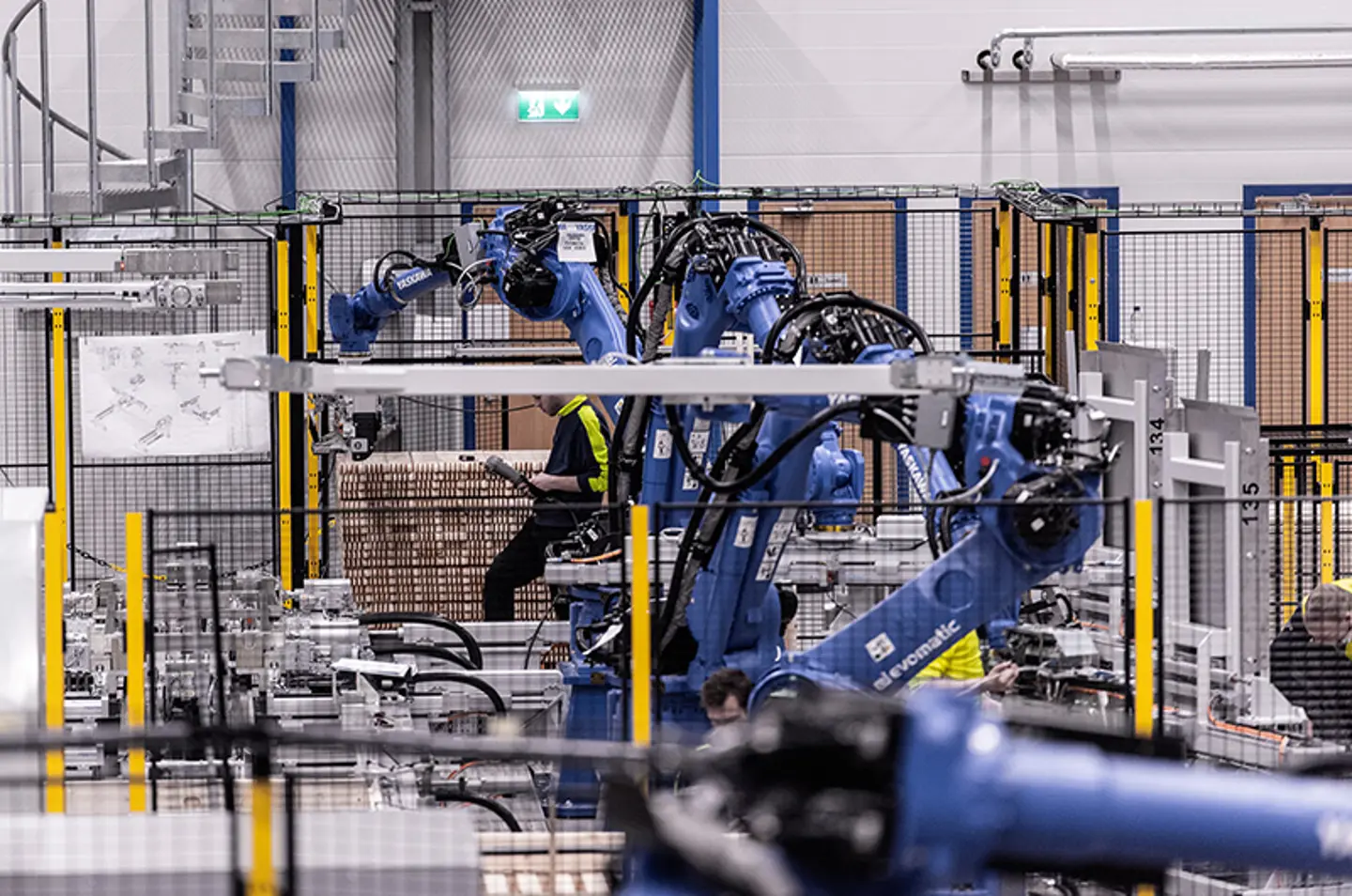 Industriële robotarmen die goederen palletiseren in een beveiligde automatiseringscel